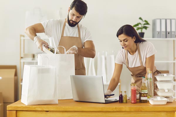 Casal de empreendedores preparando marmitas para entrega