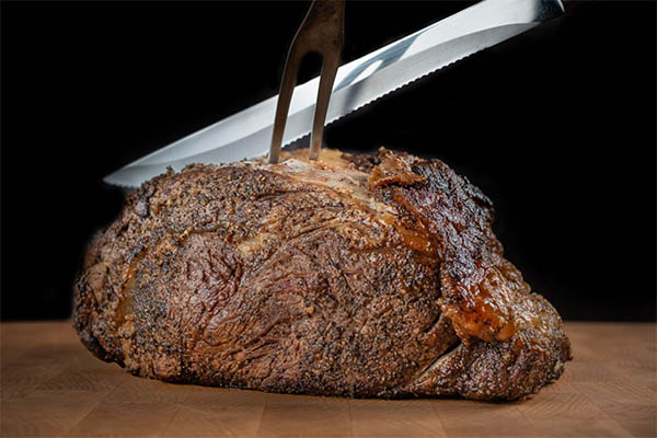 Pessoa cortando um pedaço de prime rib