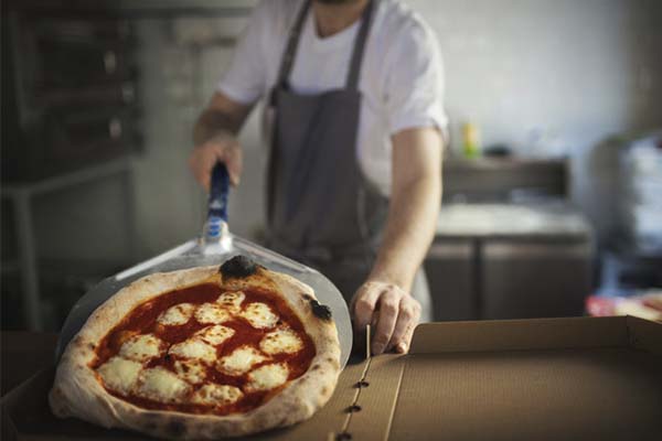 Preparando pizza para delivery em uma dark kitchen