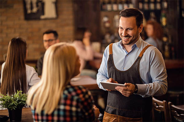 garçom realizando atendimento em restaurante